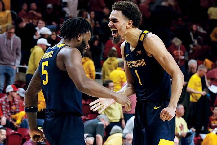 West Virginia Mountaineers forward Emmitt Matthews Jr., guard Joe Toussaint celebrate after their win over the Iowa State Cyclones at James H. Hilton Coliseum.
